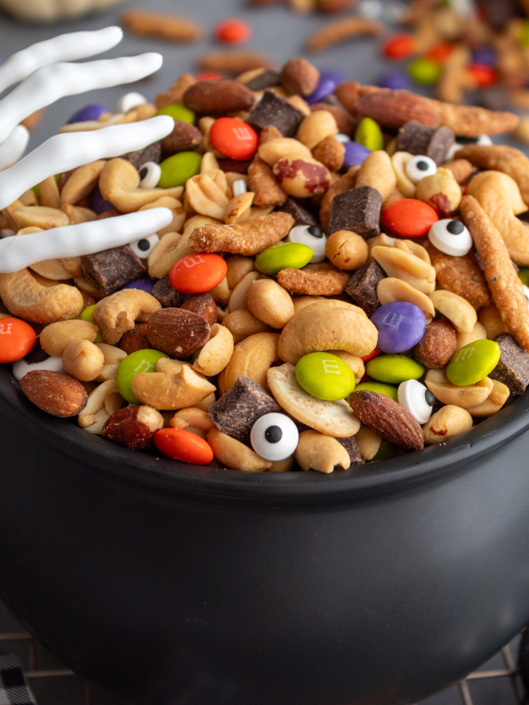 Close up of Halloween Monster Munch Trail Mix with candy eye sprinkles in a caldron bowl