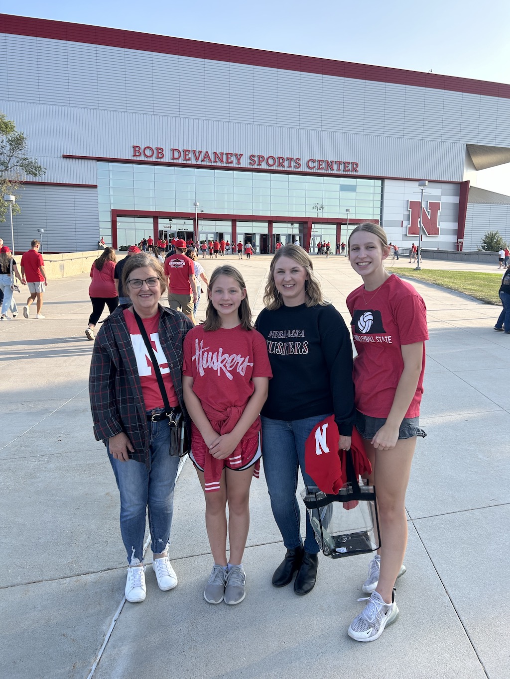 3 generations of Husker volleyball fans standing outside of the Bob Devaney Sports Center