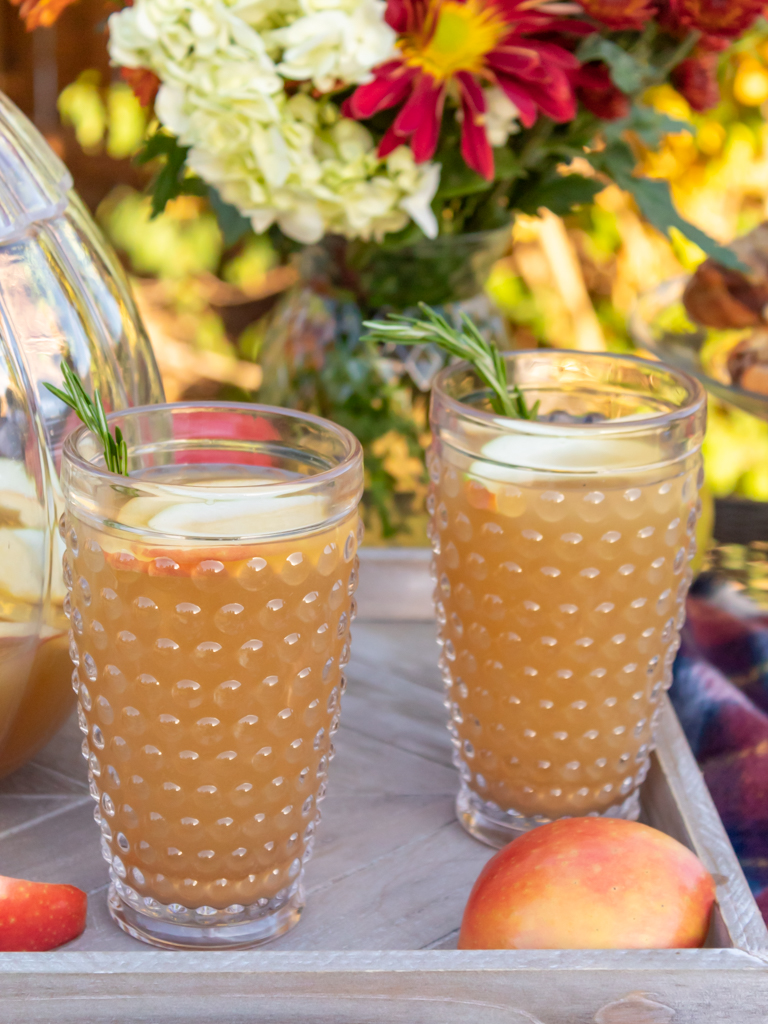 Up close view of hobnail glasses filled with fall caramel apple sangria with white wine and caramel flavored vodka