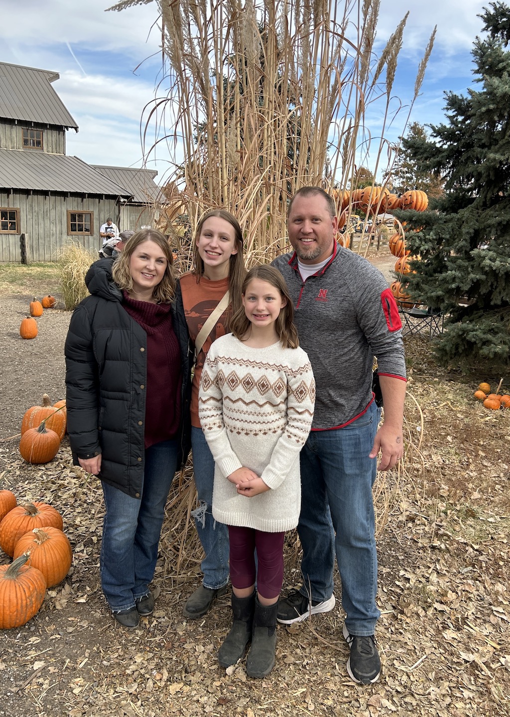 Smiling family posing for a photo at the pumpkin patch