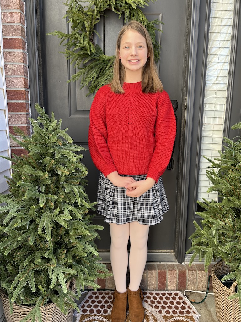 Girl standing on front porch posing before Christmas concert