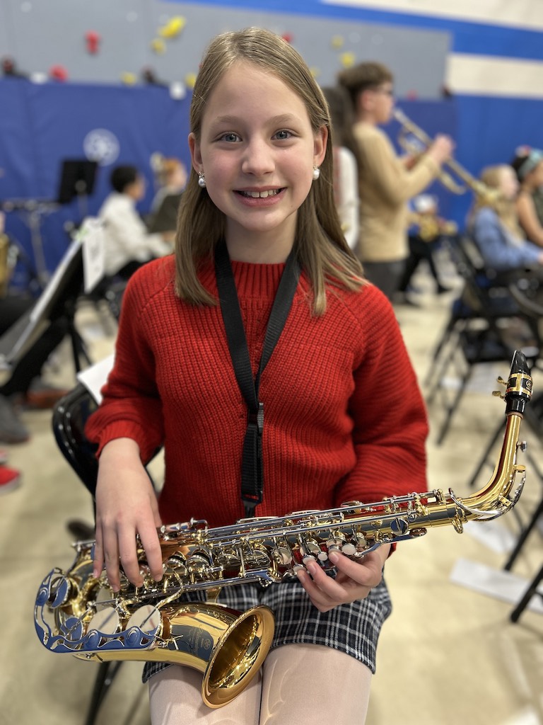 Girl holding saxophone for Christmas concert