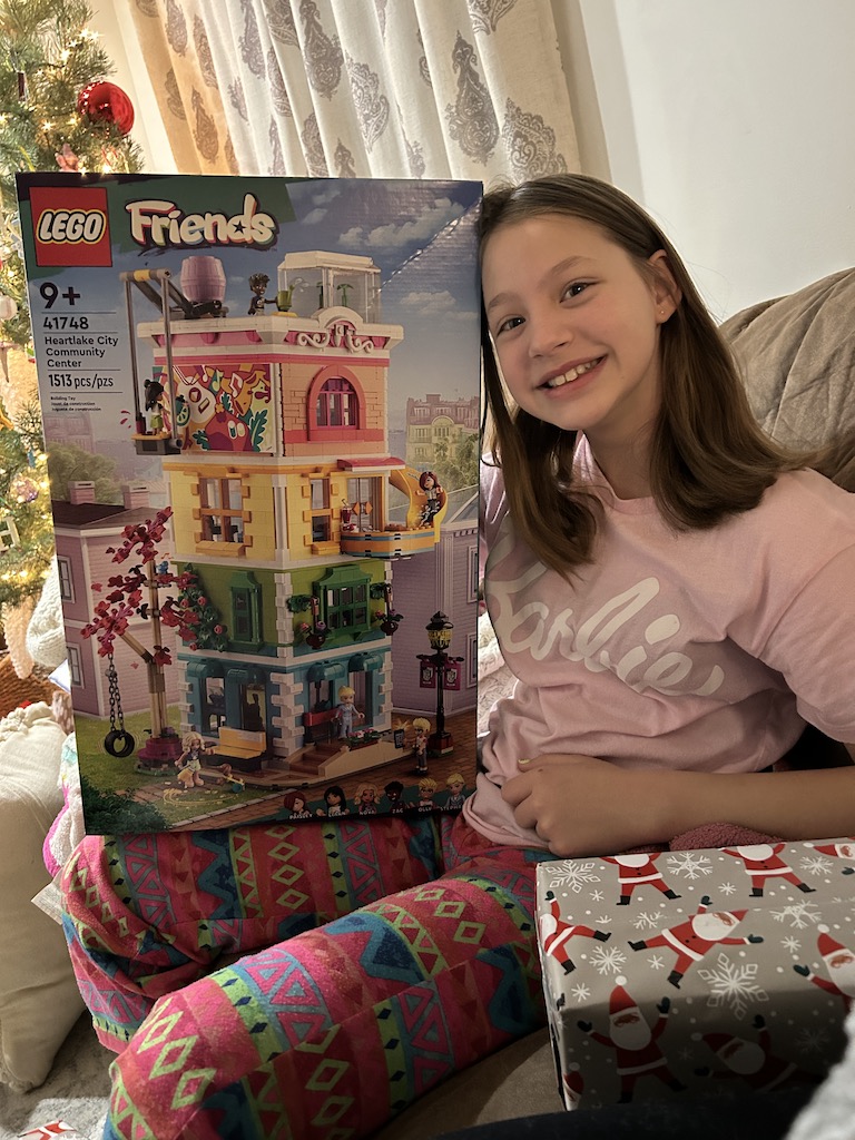 Girl smiling holiding her legos on Christmas morning