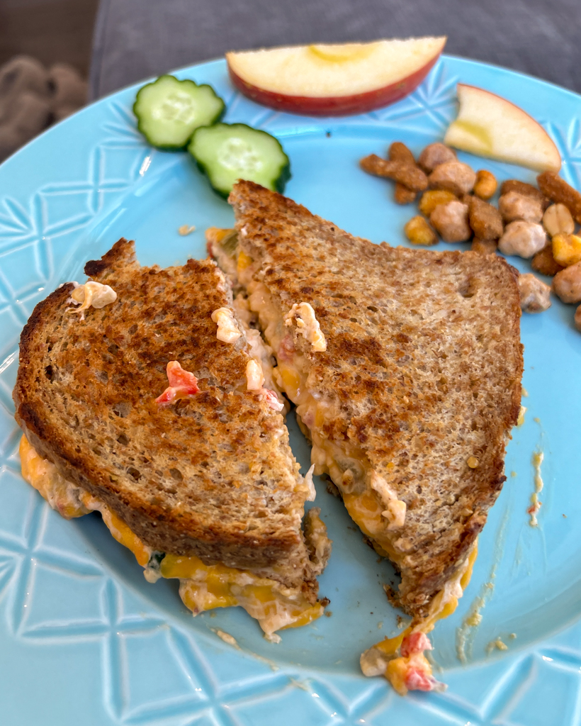 Homemade pimento grilled cheese sandwich on a turqouise plate with fruit and veggies