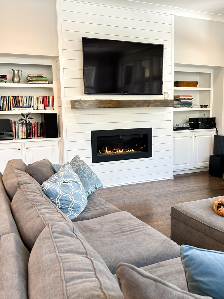 Living room with cozy seating and a fireplace and tv above the mantel in the airbnb