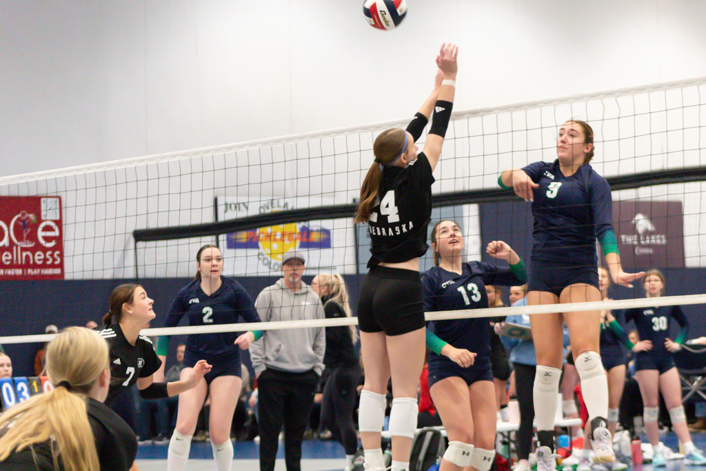 Volleyball player going up for a block against the attacker on the other side of the net