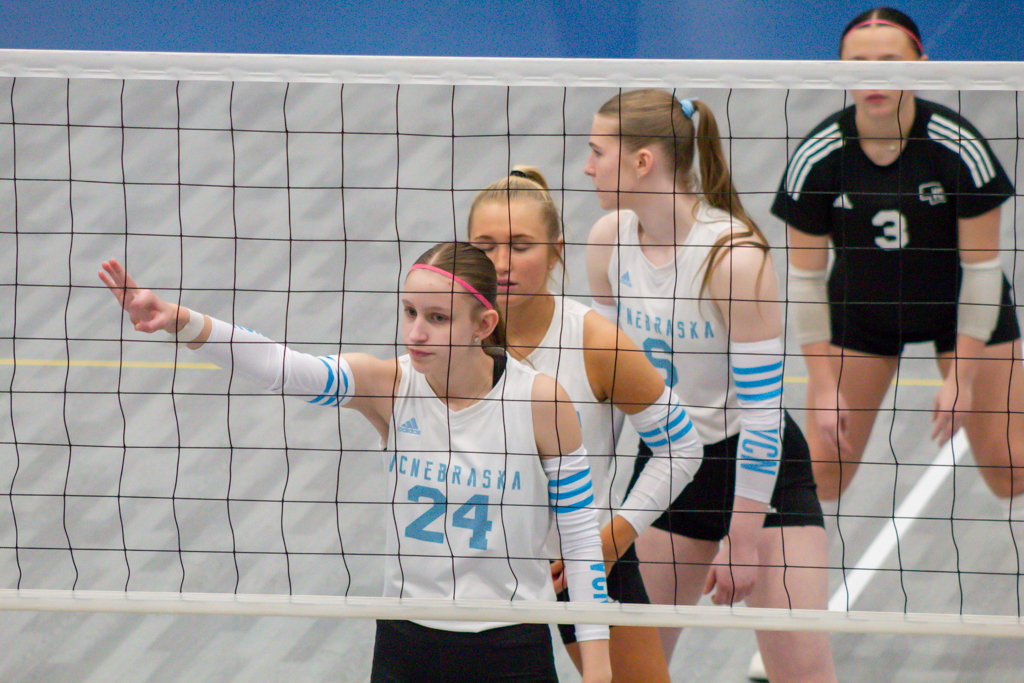 Volleyball players at the net waiting to receive serve