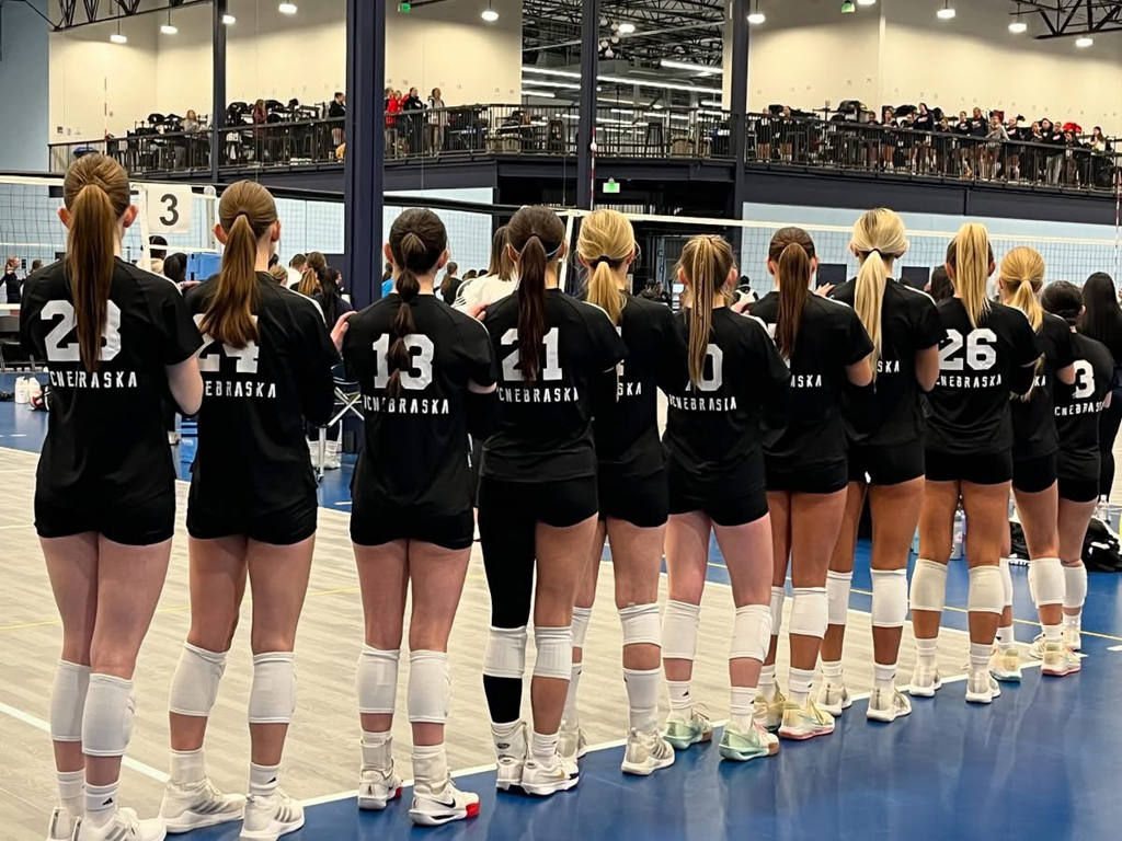 Volleyball plaeyrs lined up for the national anthem