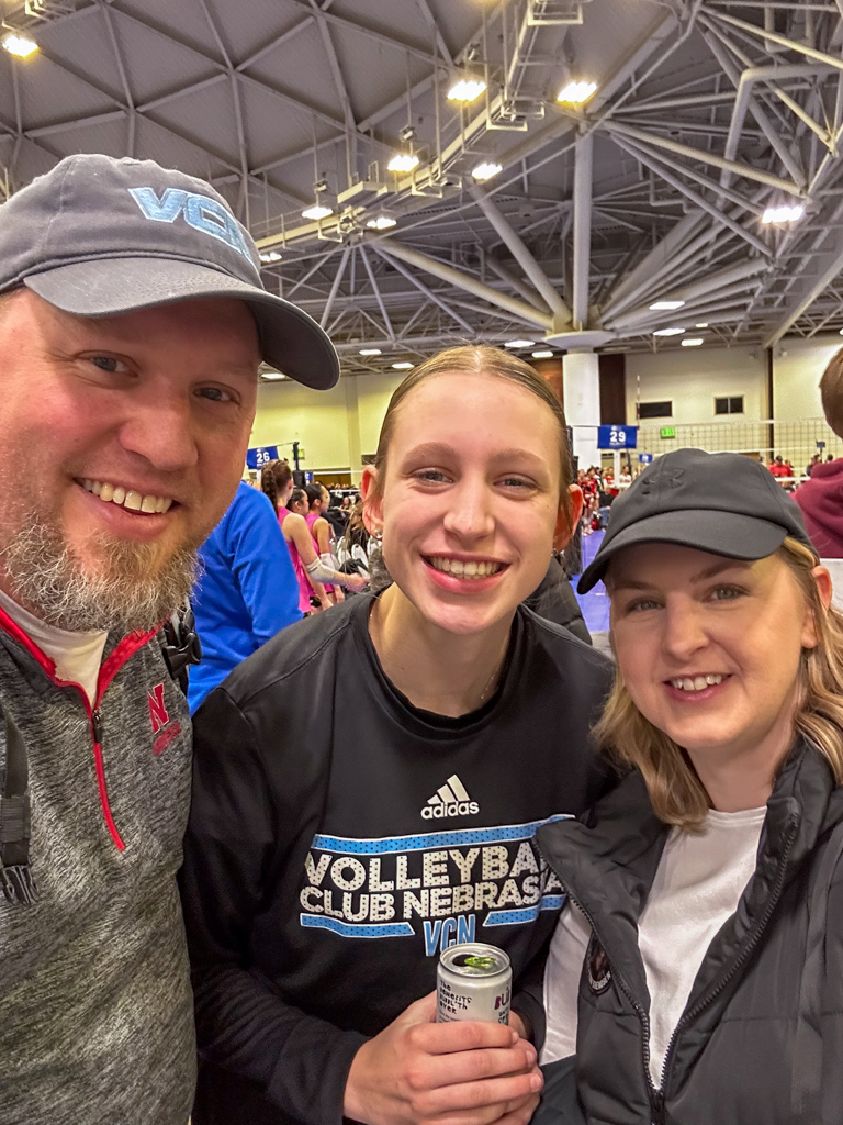 Family posing together and smiling at a club volleybal tourament